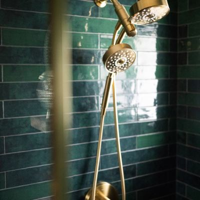 gold shower head with green waterproof shower tiles